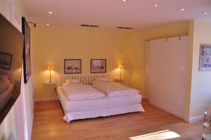 不来梅港Apartment am Bürgerpark的卧室配有白色的床和两盏灯。