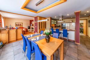 比林根Ferienhaus CAMILLO的厨房以及带木桌和蓝色椅子的用餐室。