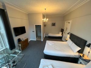 阿伯丁Lost Guest House Aberdeen的酒店客房设有两张床和电视。