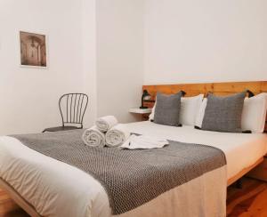 里斯本262 Baixa Guesthouse的一间卧室配有一张大床和毛巾