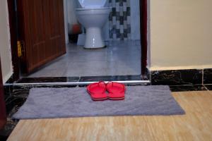 Langata RongaiSpringStone executive apartment Rm 4的浴室地毯上的一双红色鞋子