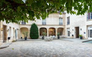 巴黎MIJE MARAIS Hostel的一座带桌椅的建筑的庭院