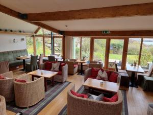 CarinishLangass Lodge的餐厅设有桌椅和窗户。