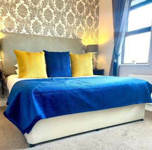基拉尼奇拉伦屋酒店的卧室内的一张带黄色枕头的蓝色床