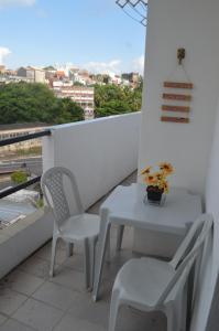 萨尔瓦多Quartos no centro de Salvador的阳台上配有一张白色的桌子和两把椅子