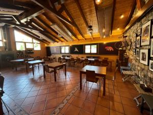 VegacerveraAlbergue Cueva de Valporquero的一间在房间内配有桌椅的餐厅