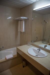 比索达雷加瑞格杜罗酒店的一间带水槽、浴缸和镜子的浴室