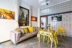 那不勒斯Museo Filangieri Apartment-Suite的客厅配有沙发和带黄椅的桌子