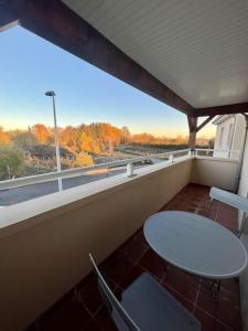 里摩日Superbe appartement - DABNB的阳台配有桌椅和窗户。