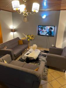 杜阿拉AU COEUR DE BONAMOUSSADI-WIFI-PARKING-GARDIENS-24H的带沙发和平面电视的客厅