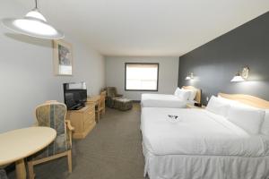 麦克默里堡Prime Hotel的酒店客房设有两张床和一张桌子。