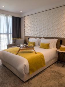 卡萨布兰卡New Hotel Piscine Wellness & Spa的一间卧室配有一张带黄色毯子的大床