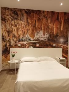 拉奎拉里维拉门酒店的卧室配有白色的床和石墙