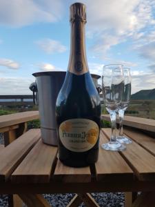DunbeathDunbeath Coastal Retreat的一瓶葡萄酒和一张野餐桌上的一杯