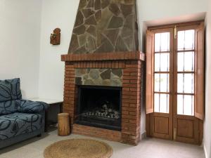 阿尔么丽亚Cortijo los Garridos - 7 huéspedes的客厅设有砖砌壁炉和门。
