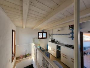 卡拉赛达Perla del mare的厨房拥有白色的墙壁和木制天花板。