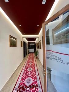 培拉特Hotel Vila Mimani的走廊上铺有红色地毯