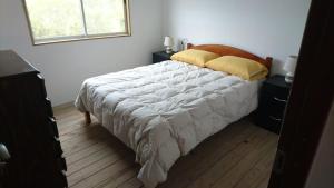 米纳斯Runa, Marcos de los Reyes villa serrana的卧室配有一张带白色棉被的床和窗户。