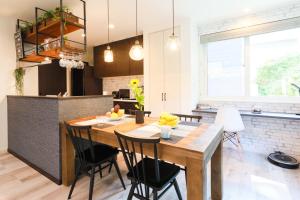 札幌TEINE WHITE HOUSE的厨房以及带木桌和椅子的用餐室。