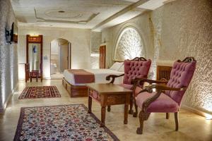 内夫谢希尔Cappadocia Sweet Cave Hotel的卧室配有一张床和一张桌子及椅子