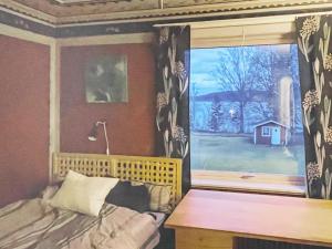 奥莫尔Holiday home ÅMÅL的一间卧室设有窗户、一张床和一张书桌