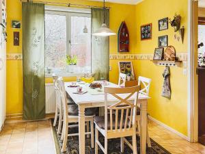 奥莫尔Holiday home ÅMÅL的用餐室设有黄色的墙壁和桌椅