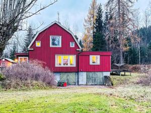 奥莫尔Holiday home ÅMÅL的红色的房子,在田野上有一个红色屋顶