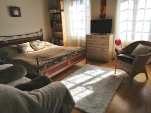 Vugelles-La Mothe皮埃罗与弗洛住宿加早餐旅馆的一间卧室配有一张床、一台电视和一把椅子