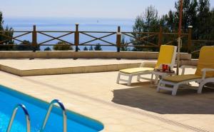 塞图巴尔昆塔多斯莫伊尼奥斯德圣菲利普酒店的一个带两把椅子的庭院和一个游泳池