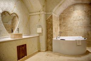内夫谢希尔Cappadocia Sweet Cave Hotel的带浴缸、水槽和镜子的浴室