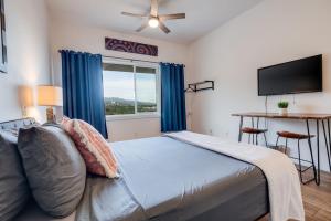 怀卢库Unit 12 Maui Ohana Modern Studio的一间卧室设有一张床、一台电视和一个窗口。