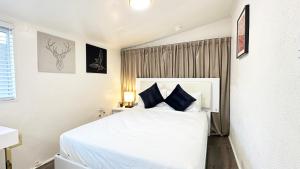 格伦代尔Spacious, Private, Modern 4 Bedroom House Plus Game Room的卧室配有带蓝色枕头的大型白色床