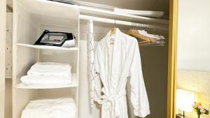 格伦代尔Spacious, Private, Modern 4 Bedroom House Plus Game Room的衣柜,配有白色长袍和打印机