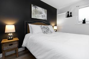 维多利亚The Royal Bay Getaway的卧室配有一张白色的床和黑色的墙壁