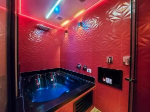 圣保罗Adrenalina Motel Itaquera - Arena Corinthians的浴室设有蓝色水槽和红色的墙壁。