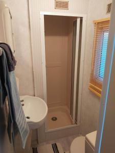 德哈恩Caravan 2 bedroom - New Camping Ideal的带淋浴、盥洗盆和卫生间的浴室
