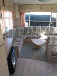 德哈恩Caravan 2 bedroom - New Camping Ideal的客厅配有沙发和桌子