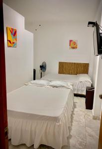 塔拉波托CASA SHILCAYO Habitaciones Vacacionales的白色墙壁客房的两张床