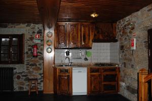 维米欧索Casa da Janal的厨房配有木制橱柜和白色冰箱。