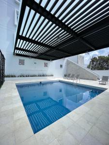 克雷塔罗Fato Hotel的一个带遮阳篷的室内游泳池和一个庭院