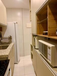 累西腓Apto moderno e bem localizado的白色的厨房配有水槽和冰箱