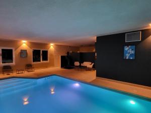 孔特雷克塞维尔Beddy-bye Hôtel的一个带客厅的室内大型游泳池