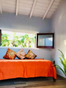 马德普拉塔Chalet Pura Vida的一间卧室配有带橙色床单的床和窗户。