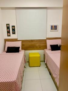 累西腓Apto moderno e bem localizado的客房设有两张床和一张黄色的桌子。