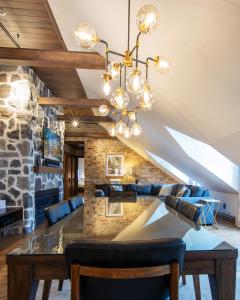 魁北克市La Maison Kent - Par Les Lofts Vieux-Québec的一间设有石墙和吊灯的用餐室