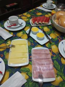 奥林达Casa da Lu的一张桌子,上面有盘子和餐具,放在五颜六色的桌布上
