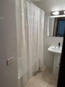埃斯特角城Hotel Club de La Barra的浴室配有淋浴帘和盥洗盆。
