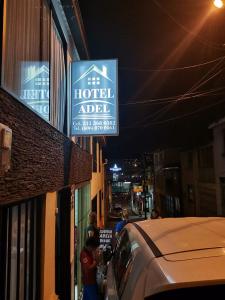 马尼萨莱斯Hotel Adel的建筑一侧的酒店标志