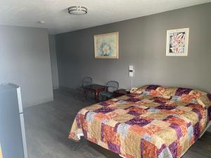 杰斐逊维尔Hoosier Travel Lodge的卧室配有一张床和一张桌子及椅子