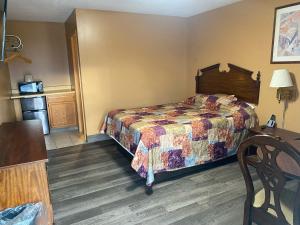 杰斐逊维尔Hoosier Travel Lodge的酒店客房配有一张床铺和一张桌子。